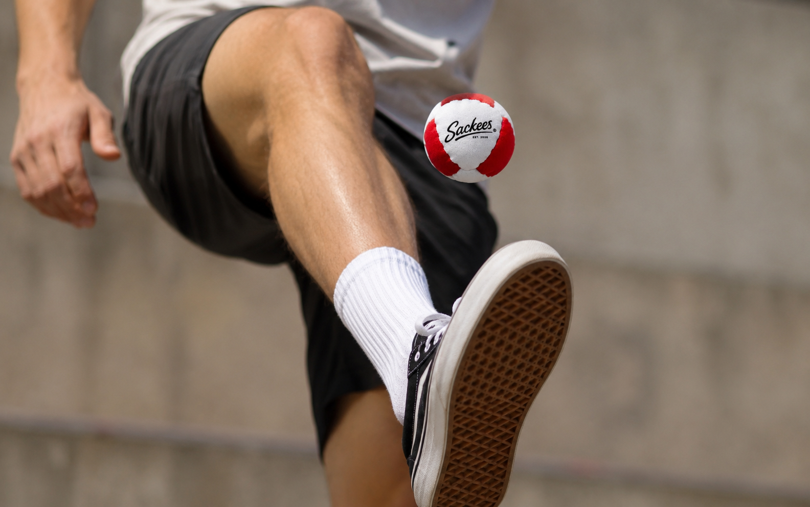 Player kicking a Sackees hacky sack